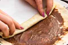 准备滚动美味的薄饼煎饼巧克力奶油关闭甜蜜的自制的甜点