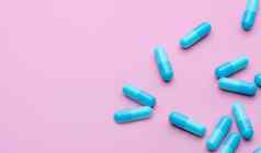 蓝色的抗生素胶囊药片传播粉红色的背景抗生素药物电阻制药行业医疗保健医学概念健康预算概念胶囊制造业行业