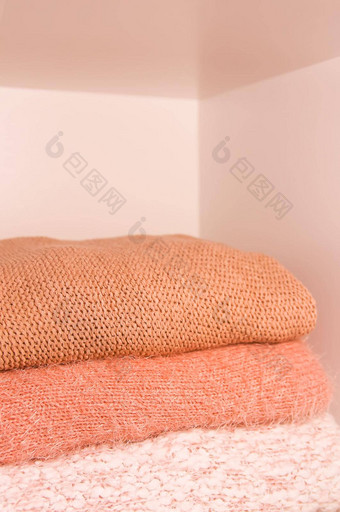桩温暖的秋天冬天针织毛衣首页衣柜架子上现代时尚衣服阴影生活珊瑚