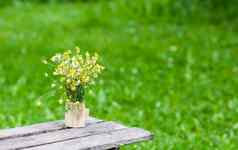 美丽的花束野花木板凳上夏天自然背景农村