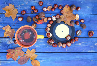 黄色的陶瓷杯Herbal茶古董乙烯基记录岁的木背景秋天秋天叶子栗子