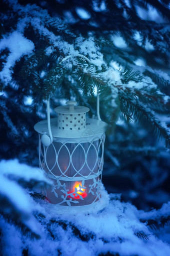 装饰圣诞节灯笼燃烧蜡烛挂白雪覆盖的冷杉树分支冬天公园一年节日卡海报明信片设计