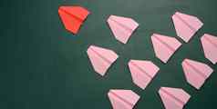 集团粉红色的纸飞机遵循红色的飞机绿色背景