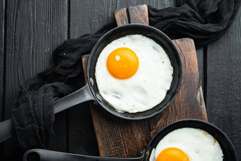 炸鸡蛋樱桃西红柿面包早餐投铁煎锅黑色的木表格背景前视图平躺