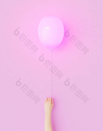 手持有粉红色的气球