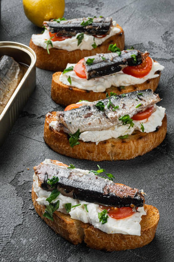 开放三明治烤面包面包ricotta鱼沙丁鱼灰色的石头表格背景