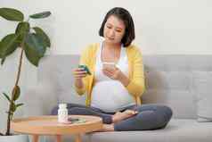 亚洲怀孕了女人移动电话搜索信息阅读医学标签处方药物