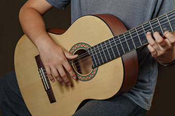 手男孩玩声吉他特写镜头声吉他玩音乐的概念声吉他生活音乐男孩音乐家戏剧吉他音乐的仪器