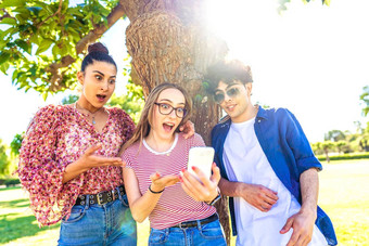 多样化的学生使惊讶脸传<strong>播口</strong>眼睛指出智能手机支出时间自然城市公园权力无线网络技术让人上瘾年龄人