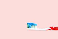 蓝色的白色牙膏牙刷孤立的粉红色的颜色背景