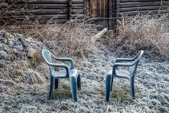 蓝色的塑料椅子冻Rime农村花园乡村农场房子草覆盖冰冷灰白色霜早期冬天早....农村概念突然冻结温度秋天冬天季节