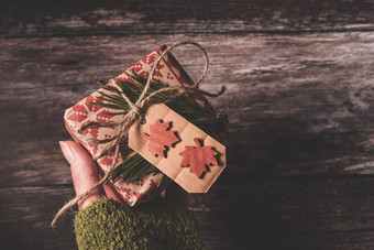 手持有<strong>小秘密</strong>圣诞节现在有创意的手工制作的装饰乡村Diy礼物包装红色的复古的包装纸自然古董线云杉树枝装饰木背景给特殊的