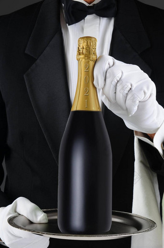 特写镜头品酒 师持有香槟瓶过时的一年银托盘男人。认不出来垂直格式