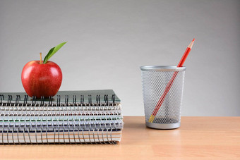 老师桌子上笔记本电脑苹果铅笔杯