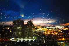 视图玻璃雨滴晚上城市日落时间晚上城市焦点