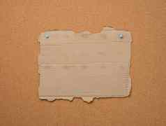 空撕裂一块棕色（的）纸板纸固定软木板的地方登记