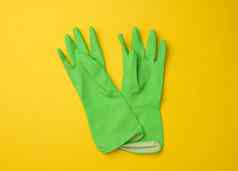一对绿色保护橡胶手套清洁黄色的背景