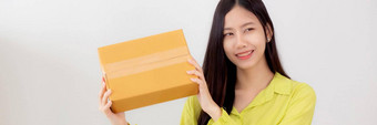 年轻的亚洲女人微笑持有纸板盒子<strong>惊喜</strong>首页快乐女携带包裹盒子兴奋现在礼物包装交付在线购物商店服务概念