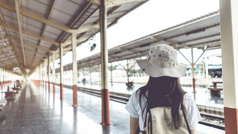 横幅古董风格年轻的女游客背包等待火车旅行火车站旅行假期概念