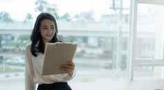横幅宽图像快乐亚洲年轻的女商人阅读公司信息报告收入明亮的工作场所