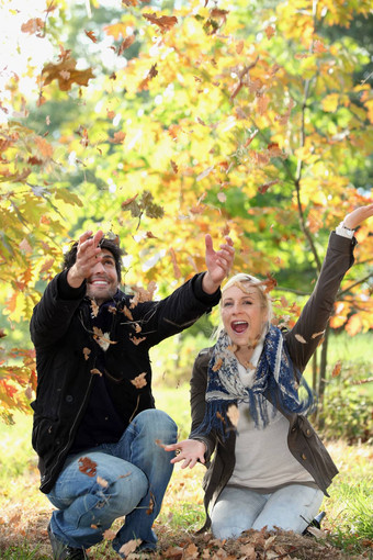 快乐的夫妇玩死叶子秋天