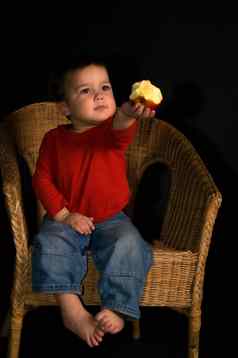 孩子坐着塔扶手椅给苹果