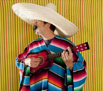 墨西哥男人。墨西哥披肩雨披帽子玩吉他
