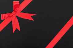 红色的缎丝带弓礼物盒子包装黑色的纸回来