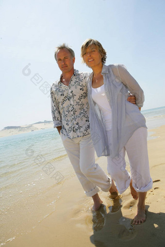 浪漫的夫妇走光着脚海滩