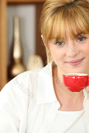 年轻的女人喝杯<strong>快报</strong>咖啡
