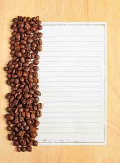 咖啡豆子纸笔记木背景