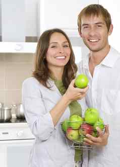 夫妇吃新鲜的水果健康的食物饮食厨房