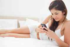 女人聚焦智能手机放松床上