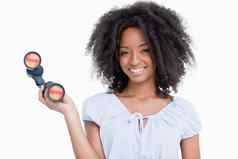 年轻的女人卷曲的发型持有双筒望远镜