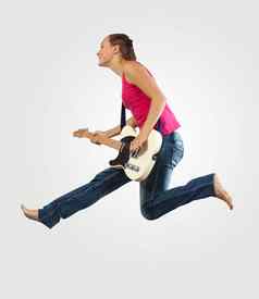 年轻的女人玩电吉他跳