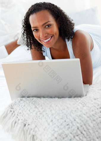 快乐的女人移动PC床上