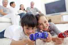 孩子们玩视频游戏地板上家庭沙发