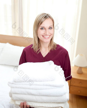 微笑清洁夫人持有毛巾酒店房间