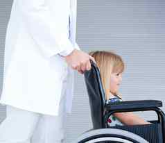 微笑女孩坐着轮椅支持医生
