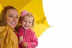 妈妈。婴儿女儿黄色的伞