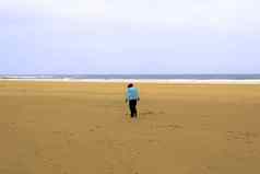孤独的女孩走海滩冷风