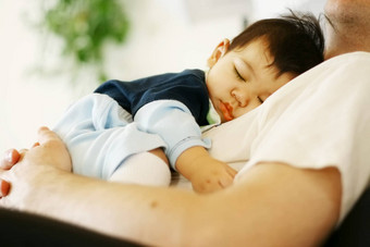 混血儿婴儿男孩睡着了父亲的胸部