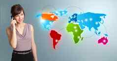 年轻的女人使电话调用色彩斑斓的世界地图