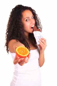年轻的女人持有橙色巧克力孤立的白色