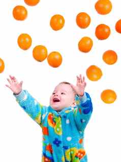 婴儿女孩抓住了飞行橙子