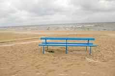 蓝色的板凳上海海洋海边海滩沙子多云的一天