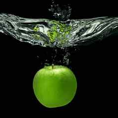 绿色苹果下降了水飞溅孤立的黑色的