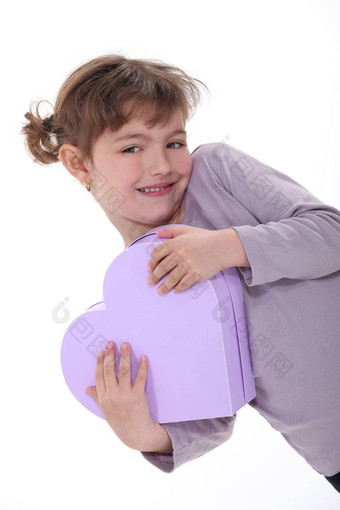 可爱的女孩拥抱心形的盒子