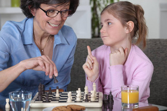妈妈。年轻的女儿玩国际象棋