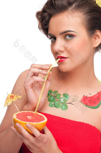 关闭年轻的女人喝葡萄柚汁